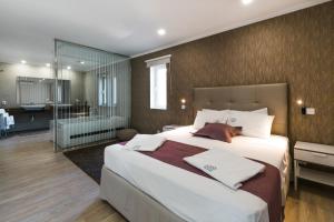 a bedroom with a large bed and a bathroom at Prana Nature in Setúbal