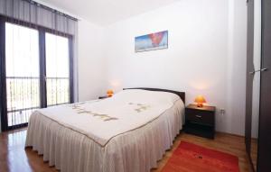 a white bedroom with a bed and a large window at Holiday home Elis in Fažana +14 photos