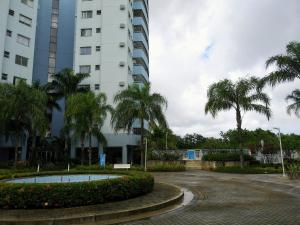 a building with palm trees in front of a building at Apartamento Vila DR - Barra da Tijuca,prox Jeunesse,Arenas,Rio Centro,praias, Shopping in Rio de Janeiro