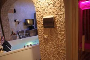 a bathroom with a bathtub with a television and a room at Afrodite Luxury Suite in Veglie