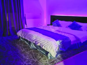 a purple bedroom with a large bed in a room at Bzul Furnished Units in Riyadh