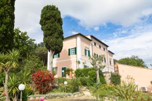 una casa con un árbol delante de ella en Appartamento Napoleone by HelloElba, en Portoferraio