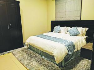 a bedroom with a large bed with blue pillows at Bzul Furnished Units in Riyadh