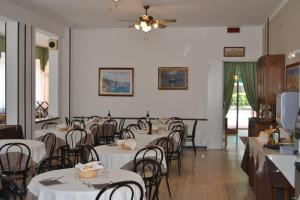 una sala da pranzo con tavoli e sedie bianchi di Hotel Mirage a Lido di Jesolo