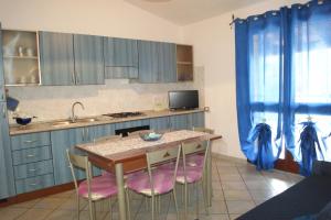 Una cocina con una mesa y algunos armarios azules. en Casa Vacanza La volpe, en Budoni 37 fotos más