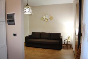 a living room with a couch and a clock on the wall at Tenuta Serena Apartments in Molfetta