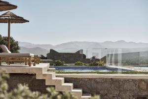 um resort com uma escadaria, um banco e uma piscina em Naxian Collection - Small Luxury Hotel of the World em Stelida
