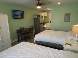 a bedroom with two beds and a table and a kitchen at The Catalina in Panama City Beach +28 photos