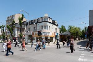 a group of people crossing a street in a city at ANTIQUES & GOLD Boutique Guesthouse in Varna City