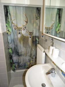 a bathroom with a shower curtain with two deer on it at Ferienhäuschen in Inzell +22 photos