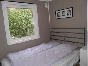 1 cama en un dormitorio con ventana en Fjellheim en Herlø