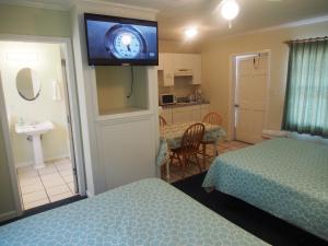 a hotel room with two beds and a tv on the wall at The Catalina in Panama City Beach