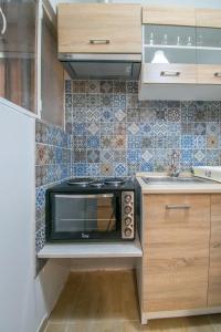 een kleine keuken met een magnetron en een wastafel bij Urban studio in Athens, next to Sygrou- Fix metro in Athene