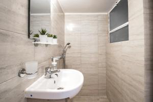 een badkamer met een wastafel en een spiegel bij Urban studio in Athens, next to Sygrou- Fix metro in Athene