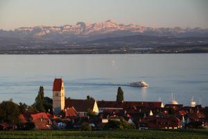 ein Kreuzfahrtschiff im Wasser mit einer Stadt und einer Stadt in der Unterkunft Hotel Restaurant Hansjakob in Hagnau