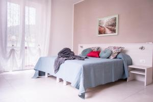 a white bedroom with a bed with pillows at Appartamento IRIS in Garda