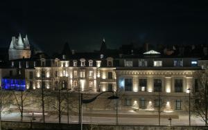 a large building with lights on it at night at Le Magic Hôtel & Spa in Vitré