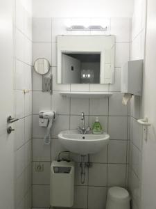 a white bathroom with a sink and a toilet at Mike's Four in Düsseldorf