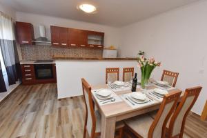 LEA في شيبينيك: غرفة طعام مع طاولة وكراسي ومطبخ