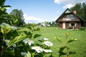 a house in the middle of a field with flowers at Melderi in Rēzekne
