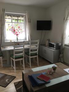 a living room with a table and a desk and a window at Kornblume in Rabenholz