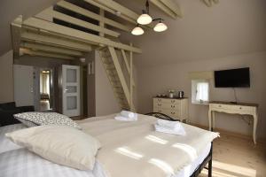 1 Schlafzimmer mit 2 weißen Betten und einem TV in der Unterkunft Penzion Dobré časy in Valtice