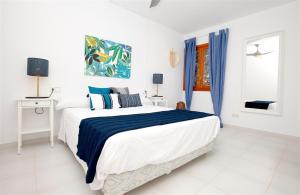 a white bedroom with a large bed and a window at Apartments Es Trenc in Ses Covetes +64 photos