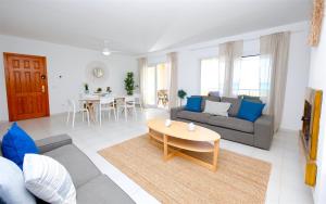 een woonkamer met een bank en een tafel bij Apartments Es Trenc in Ses Covetes