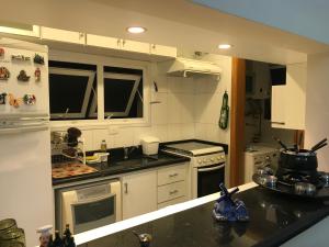 cocina con electrodomésticos blancos y encimera en Chateau du Loire Apartamento, en Campos do Jordão