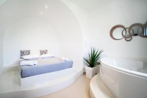 a white bathroom with a bed and a bath tub at Hotel Summer Dream in Kamari