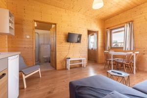 a living room with a table and a tv at Lesna Domki Letniskowe in Ustka