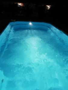 - une grande piscine d'eau bleue la nuit dans l'établissement Residence Clementine villa Douceur, à Grand-Bourg
