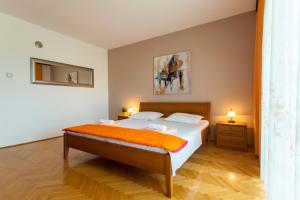 a bedroom with a bed with an orange blanket at Apartment Meri in Krk