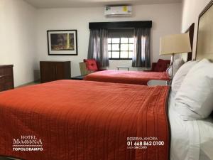 a hotel room with two beds and a living room at Hotel Marina Topolobampo in Topolobampo