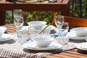 a table with plates and bowls and glasses on it at Villa Agape in Kala Nera