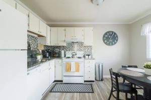 a kitchen with white cabinets and a table and a clock at Cute Condo in Rock Hill-57 in Rock Hill