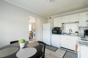 a kitchen with a table and a kitchen with white cabinets at Cute Condo in Rock Hill-57 in Rock Hill
