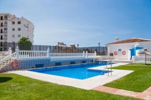 a swimming pool in a yard next to a building at Verano Azul 61B Nerja in Nerja