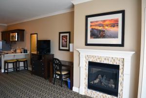 a living room with a fireplace and a kitchen at Majestic Inn and Spa in Anacortes