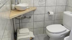 a bathroom with a white toilet and a sink at Apart Costanera in Villa Pehuenia +11 photos