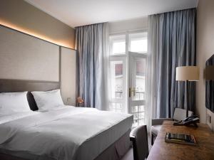 um quarto de hotel com uma cama e uma janela em The Emblem Prague Hotel - Preferred Hotels & Resorts em Praga