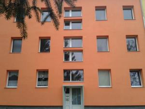 un bâtiment orange avec des fenêtres blanches dans l'établissement Natur-Freude-19p, à Kotzen