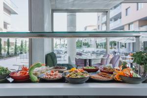 a buffet line with bowls of food on a table at Elysia Park in Paphos