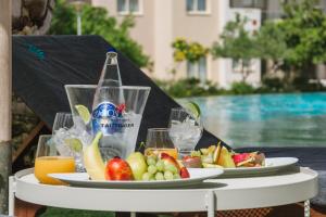 a table with plates of fruit and a bottle of water at Elysia Park in Paphos