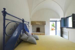 Un dormitorio con una cama azul con almohadas. en Masseria delle Pecore, en Specchia