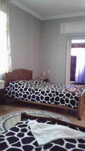 a bedroom with a bed with a black and white comforter at Toma's vila in Borjomi