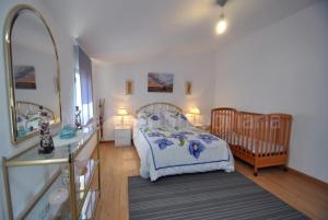 a bedroom with a bed and a crib and a mirror at Casa MAREIRA - VACACIONES en el mar in Vilagarcia de Arousa