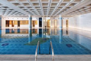 a swimming pool with chairs in a building at Elysia Park in Paphos