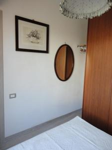 Schlafzimmer mit einem Spiegel an der Wand und einem Bett in der Unterkunft Sardinia Holidays - Domus Patrizia in Quartu SantʼElena