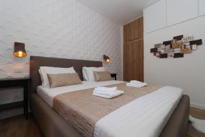 a bedroom with a large bed with towels on it at Cicibela Apartment - Zadar in Zadar